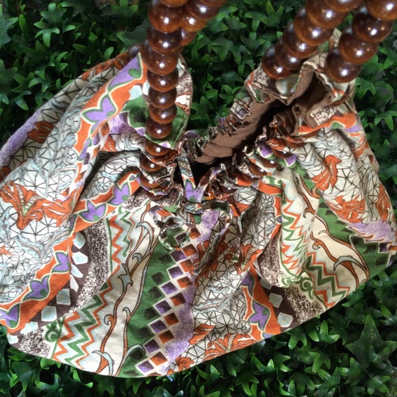 Reversible hobo tote with brown wood balls straps. Has a tie strap closure. - Picture 3 of 10